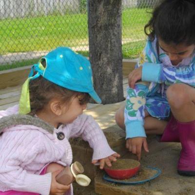 two young girls playing in the sand