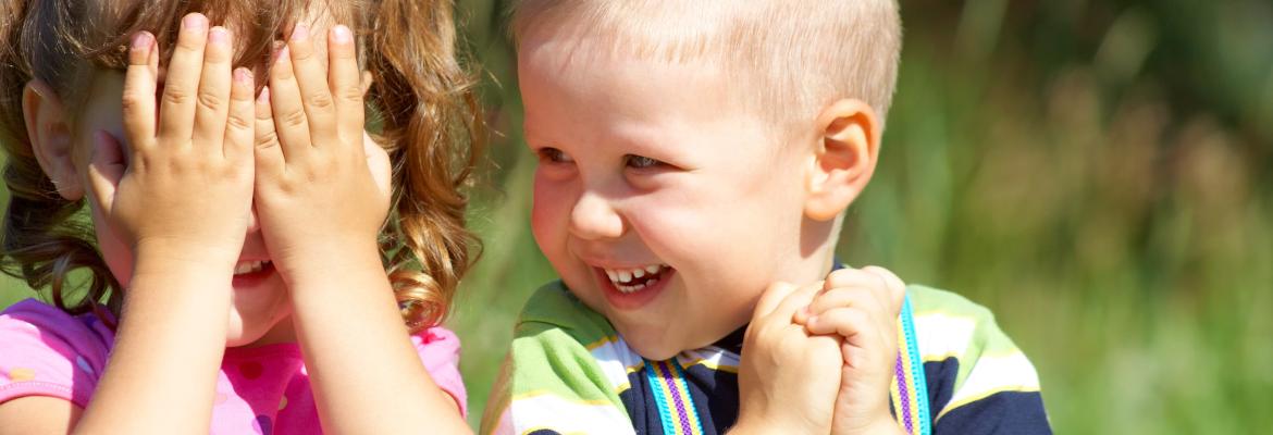 two young children standing side by side and giggling